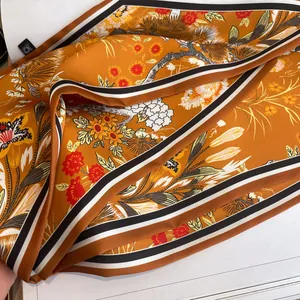 Elegante sciarpa in seta arancione con motivi floreali e bordo a righe sottili