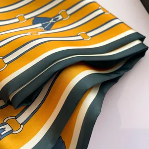 Elegant silk scarf featuring classic belt and buckle patterns in orange and green