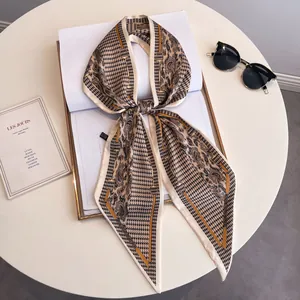 Écharpe longue en mousseline avec motifs pied-de-poule et paisley sur table chic