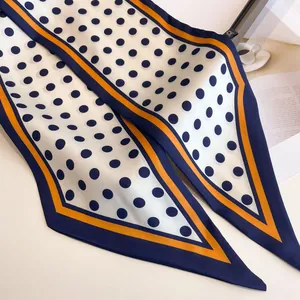 Navy blue polka dot long skinny silk scarf with orange striped border on white background