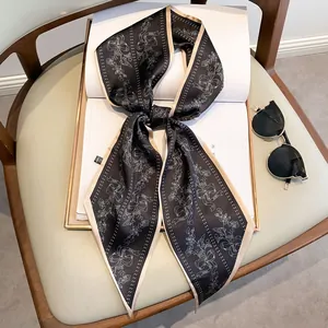 Eleganter schwarzer Seidenschal mit Blumenmuster und 'HAPPY' Print auf einem Buch