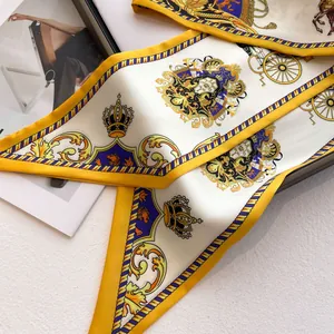 Élégant foulard en soie dorée aux motifs royaux vintage présenté plié avec soin