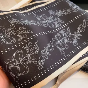 Detail eines schwarzen Satin-Halstuchs mit elegantem Blumendruck und beiger Saumnaht