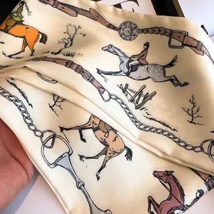 Detailed close-up of a vintage horse print silk scarf with equestrian patterns on beige