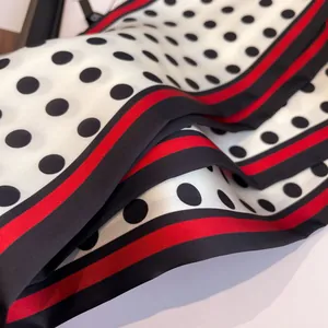 Detail of silk scarf with classic polka dots and red-black striped border texture