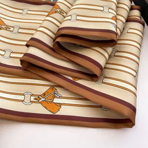 Close-up of premium silk scarf with classic horsebit pattern and elegant draping texture