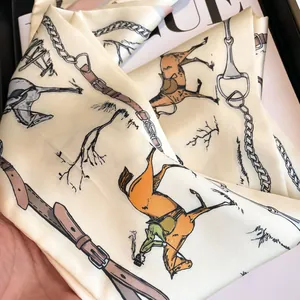 Detailed shot of silk satin scarf featuring equestrian horse prints and metal harness patterns