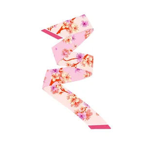 Detail of pink silk twilly scarf with cherry blossom pattern and elegant soft texture