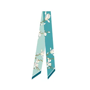 Detail of lake green silk twilly with white magnolia floral print and dark green trim