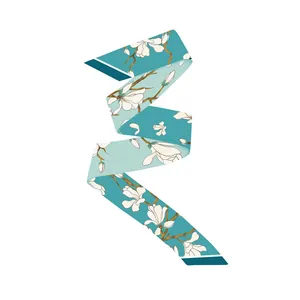 Detailed view of teal silk twilly scarf with elegant white magnolia flower floral patterns