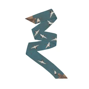 Detail of dark teal silk twilly showing elegant white crane patterns and twill texture