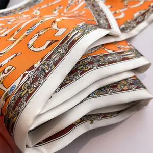 Close-up of luxury silk scarf showing twill texture and equestrian chain pattern