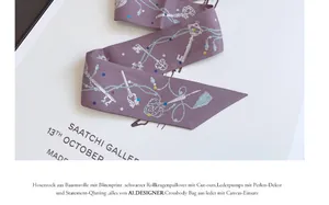 Detalle de pañuelo de seda violeta con motivos de llaves vintage sobre un libro de arte