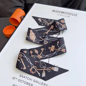 Pañuelo twilly de seda con motivos de llaves doradas y cadenas sobre seda para bolsos