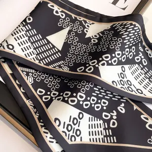 Elegant black and white silk scarf with geometric patterns and champagne gold borders