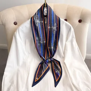 Foulard étroit en soie à motif baroque et rayures noué sur un col de chemise blanc