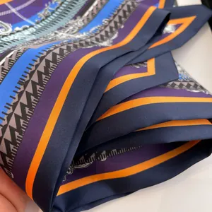 Gros plan sur la texture d'un foulard en soie aux motifs géométriques vintage bleu et orange