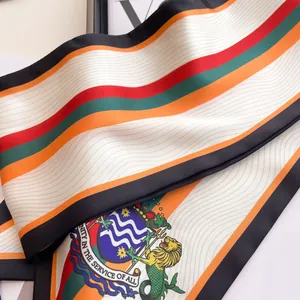 Détail d'un foulard en soie à rayures avec impression héraldique et lion coloré