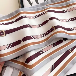 Détail d'un foulard en soie rayé avec motif de boucles vintage et texture satinée lisse