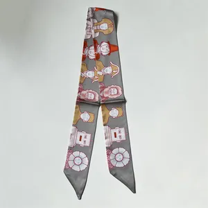 Détail d'un twilly en soie grise avec des illustrations artistiques et motifs floraux
