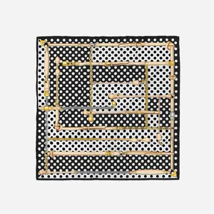 Elegant silk scarf featuring classic black and white polka dots with gold chain pattern