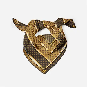 Detailed view of silk scarf with classic polka dot and golden chain patterns