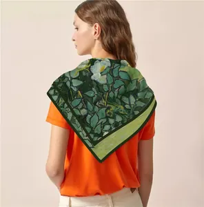 Detail of oil painting leaf print silk scarf draped over model's shoulder in bright style