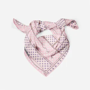 Close-up of pink silk scarf with purple polka dots and chain pattern in a stylish knot
