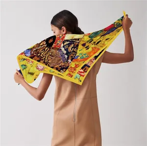 Detail of yellow silk scarf featuring Klimt gold art print style on female model