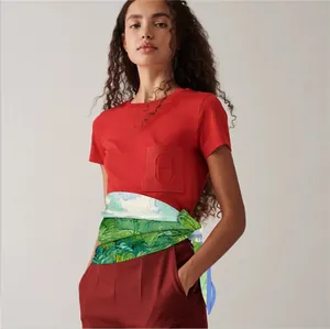 Détail d'un foulard en soie style peinture à l'huile porté en ceinture avec un t-shirt