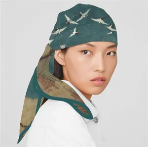 Dettaglio di un foulard in seta con motivo a gru indossato come copricapo elegante