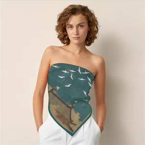 Pañuelo de seda con estampado de grullas chinas usado como un elegante top bandeau