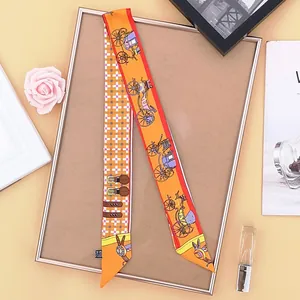Detailed view of an orange twilly silk scarf with carriage patterns and geometric accents