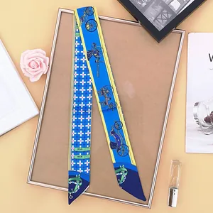 Detail of a blue and yellow silk twilly featuring classic carriage and geometric patterns
