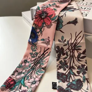 Close-up van vintage bloemen zijden sjaals in roze en beige op een wit boek