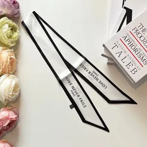 Elegant white silk-like twilly scarf with black edges and Love Never Fails Paris print