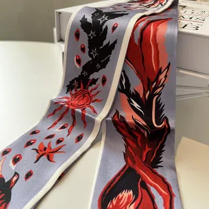 Detailed close-up of a blue silk twilly scarf with artistic sun and star patterns