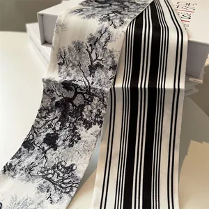 Detail of narrow silk-like twilly scarves with Toile de Jouy print and stripes