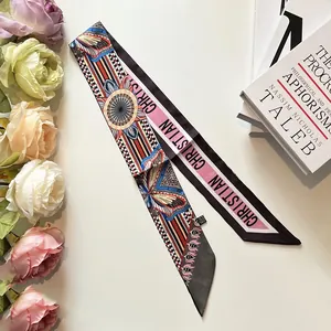 Détail d'un foulard twilly imprimé avec des blocs géométriques et des motifs floraux élégants