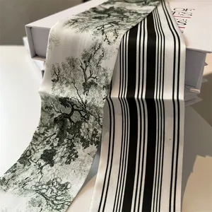 Detail of silk twilly scarf with forest landscape and black white stripes on book box