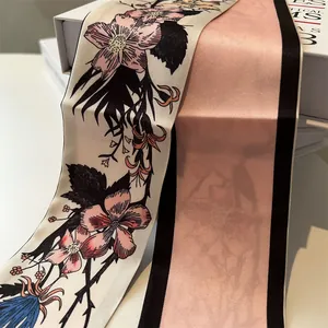 Detail of floral silk scarf showing elegant pink petal pattern and satin texture on a gift box
