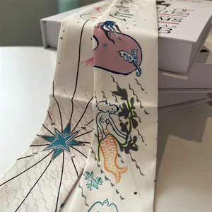 Detail view of cream long silk scarf featuring nautical mermaid and whale illustrations