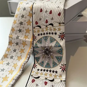 Détail d'un twilly en soie crème aux motifs d'étoiles et d'abeilles sur un coffret