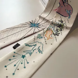 Macro detail of silk twilly ribbon featuring hand-painted stars and bird patterns