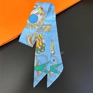 Narrow silk scarf with geometric celestial patterns on a vibrant orange background