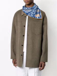 Detailed view of a blue printed silk scarf with wave and palm patterns on a model