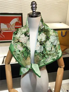 Sciarpa in seta con stampa floreale artistica verde su un manichino femminile bianco