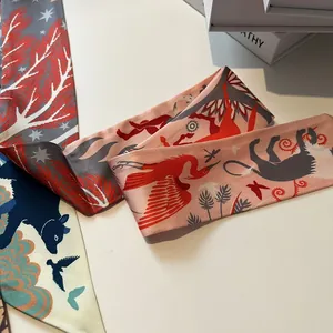 Detailed view of assorted silk twilly scarves with vibrant jungle and bird prints
