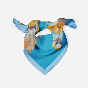 Detail eines blauen Seidenschals mit eleganten gelben und orangefarbenen Blumenmustern