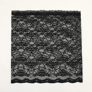 Detailed macro view of black floral lace fabric with delicate scalloped edges and roses
